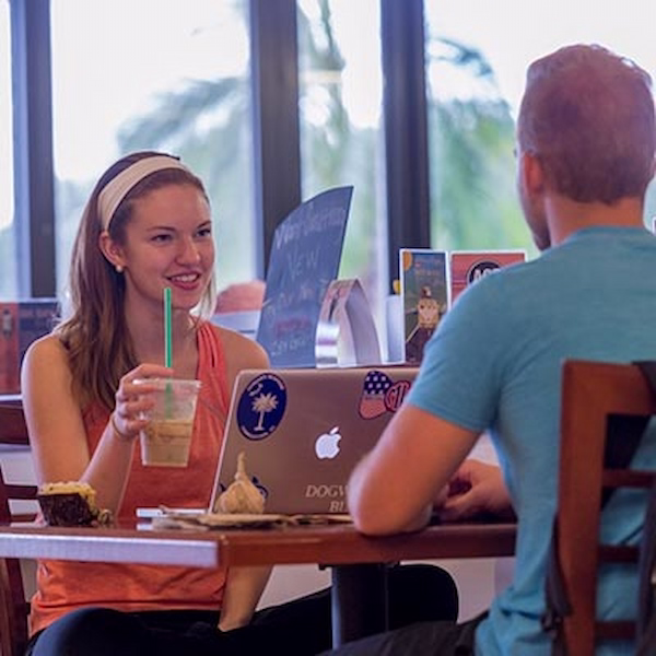Students drinking coffee and working on laptops at tutu's cafe