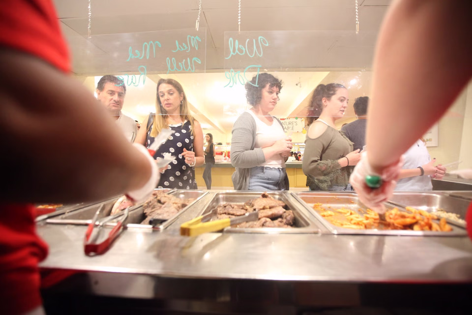 Roasted meat and french fries being served to students