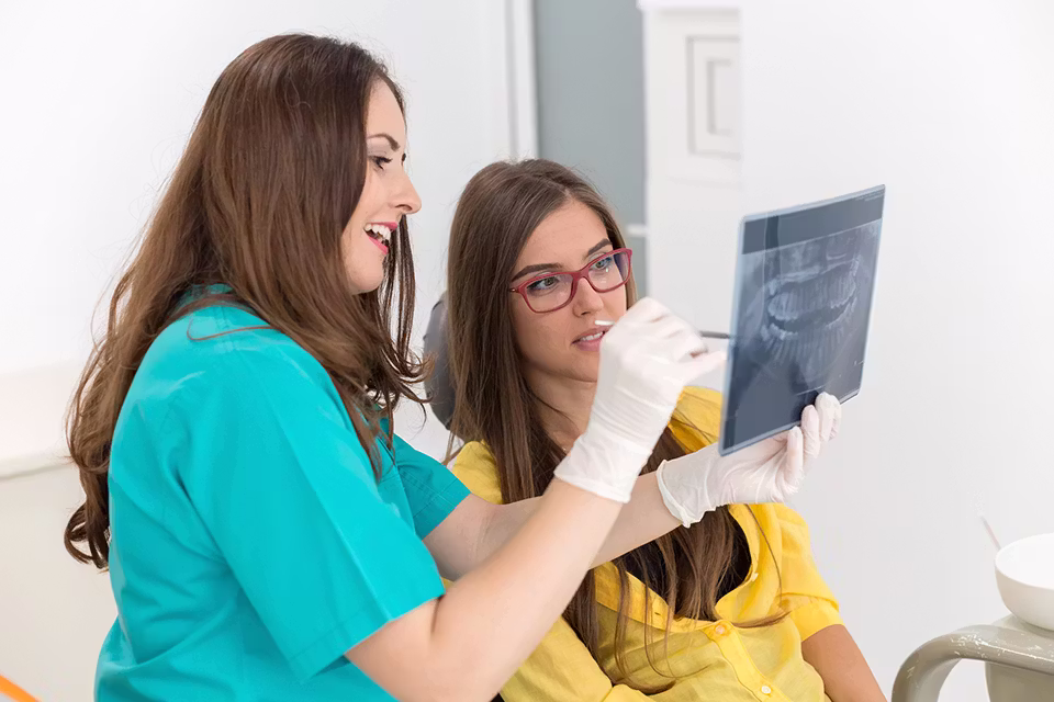 dentist looking at teeth x-rays with a patient