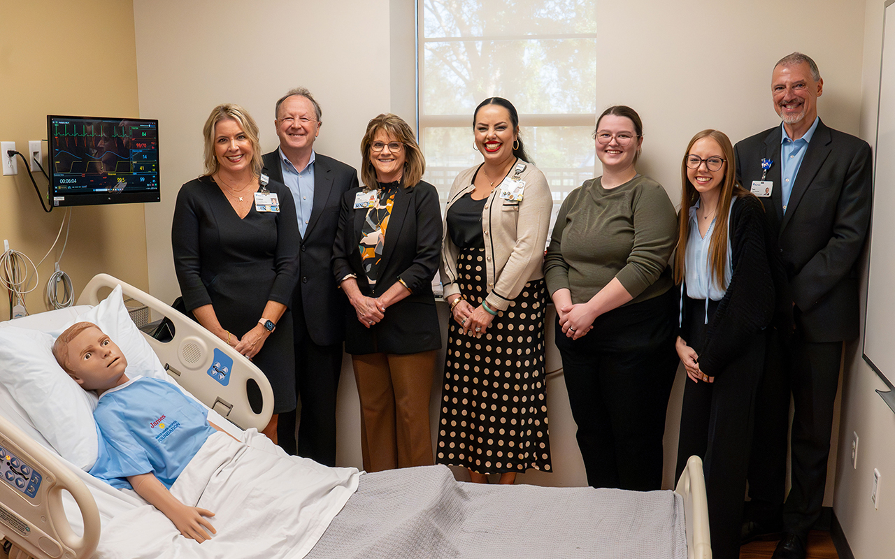 representatives standing in front of a nursing training dummy