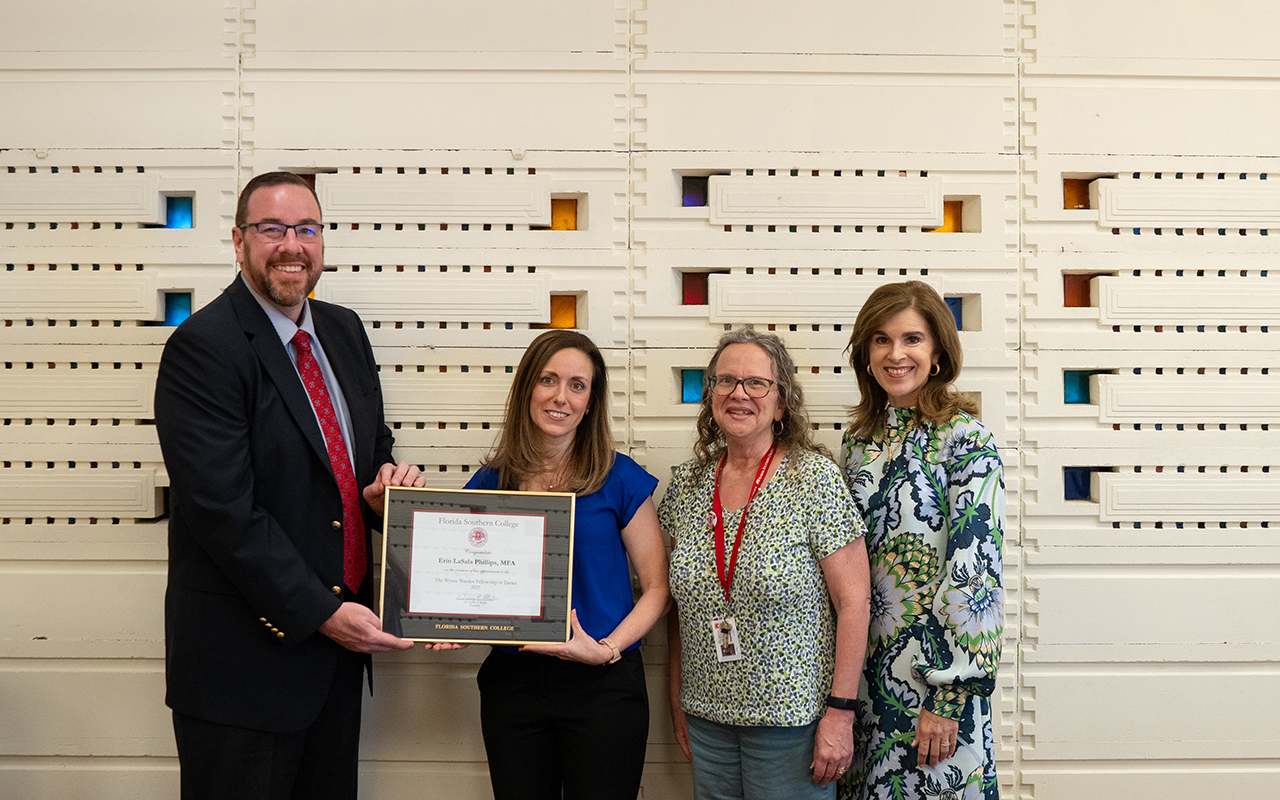 Dr. Jeremy Martin hands Erin Lasala Phillips a plaque