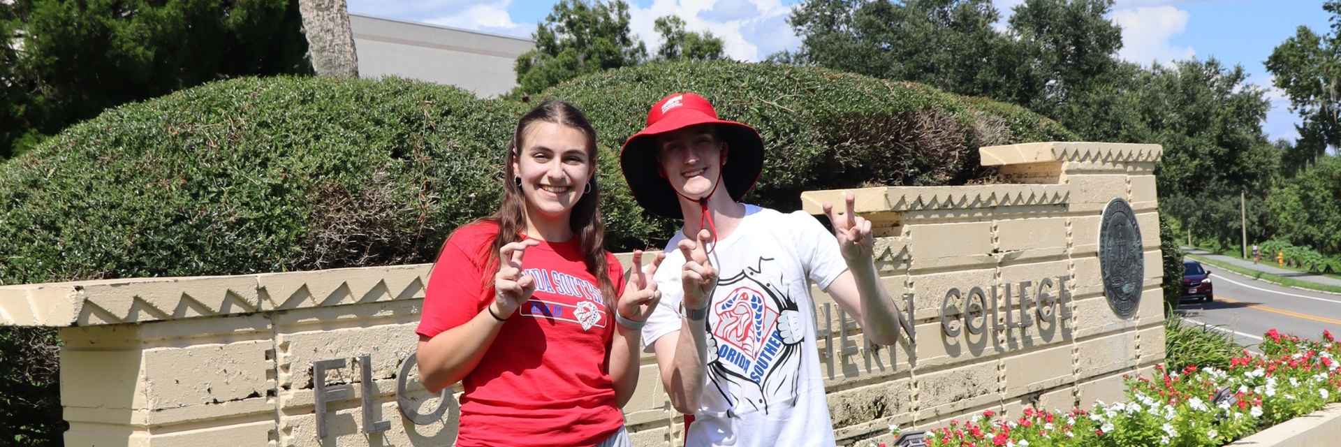 two students making the Mocs hand gesture