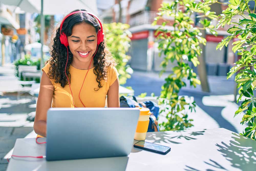 student on computer with headphones